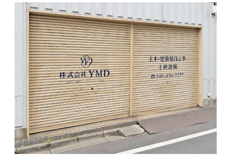 紺色のカッティングシートでロゴをいれた建設会社のシャッターサイン