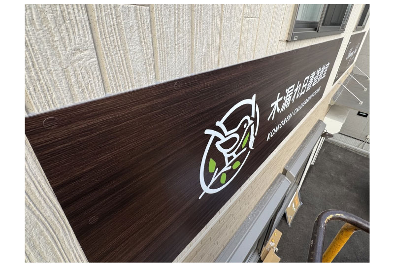 木目調のデザインの書道教室の壁面看板のアップ